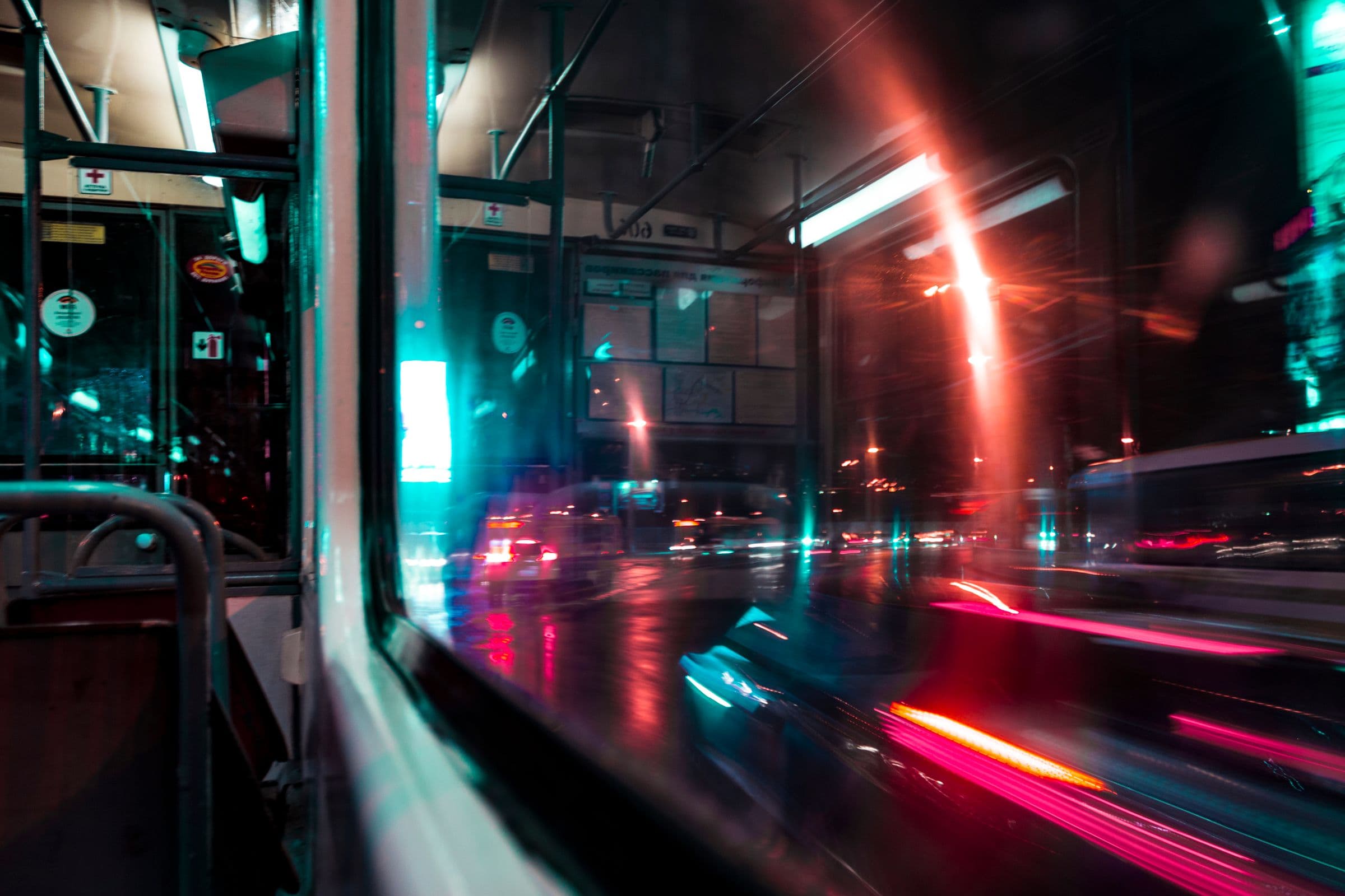 City lights streaking past the window of a night tram